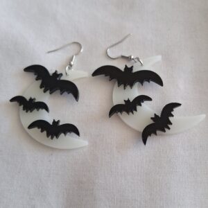 Pale coloured crescent moon earrings with three black bats