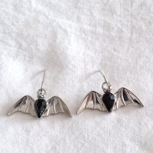 Small silver coloured batwing earrings with central black stone
