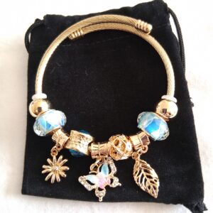 Blue and gold coloured charm bracelet with hanging butterfly, flower and leaf with gold coloured and flowered design beads