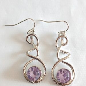 Hanging silver coloured earrings with purple glass stone